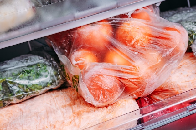 Different kind of deep frozen vegetables in plastic bags in a refrigerator