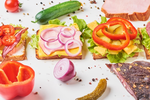 Different kind of sandwich and ingredients on a white background, close up