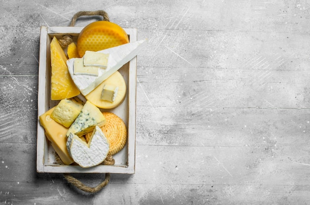 Photo different kinds of cheese in wooden tray