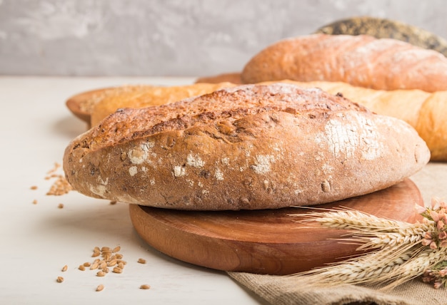 Different kinds of fresh-baked bread on a white background