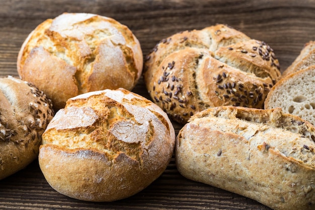 Different kinds of fresh bread on wooden table Isolated assortment of bread on brown background