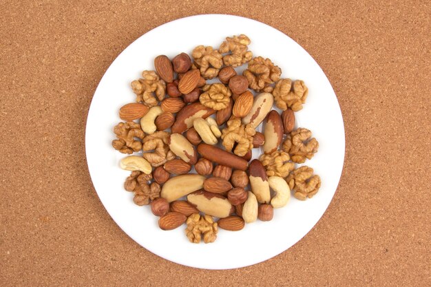 Different kinds of nuts on a white plate. Healthy and protein food