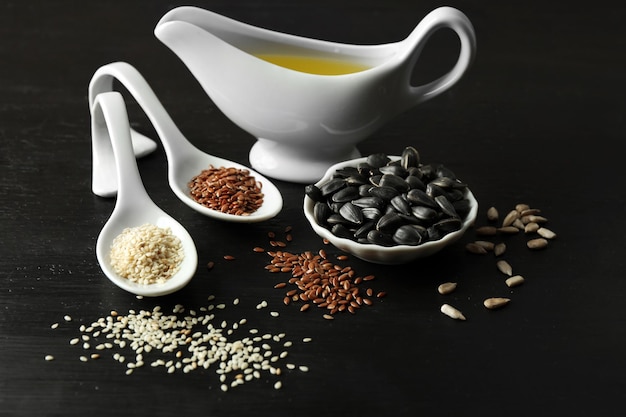 Different kinds of seeds and oil on wooden table