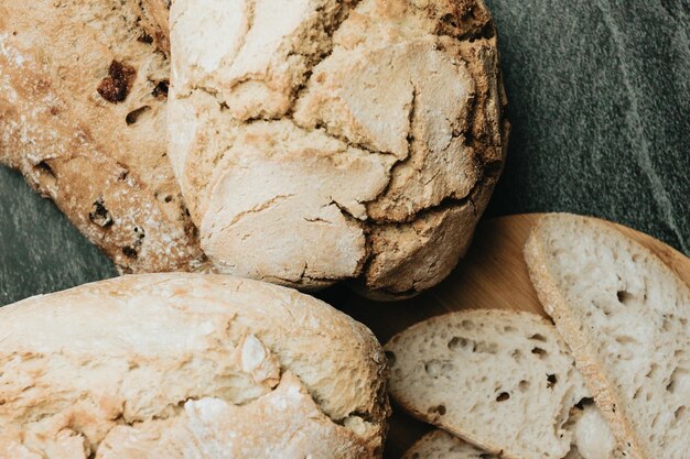 Different kinds types of freshly baked artisan and organic bread over a rustic table Homemade cooking Sourdough bread with crispy crust on wooden shelf Bakery goods concept Restaurant and goods