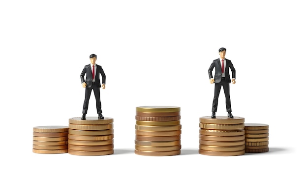 Different miniature businessman standing on different height coins stacking Inequality income and