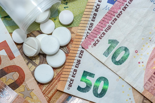 Different pills medications with european money as background expensive cost of healthcare