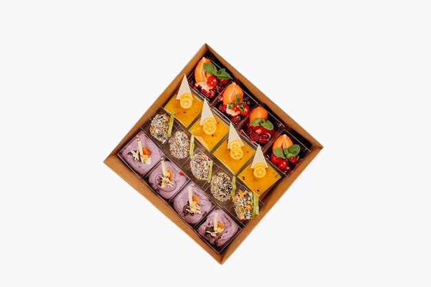 Different portions of desserts with jelly and fruit in a box are ready for delivery