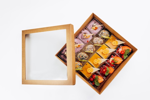 Different portions of desserts with jelly and fruit in a box are ready for delivery