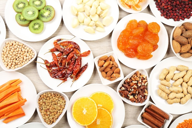 Different products on saucers on wooden table top view