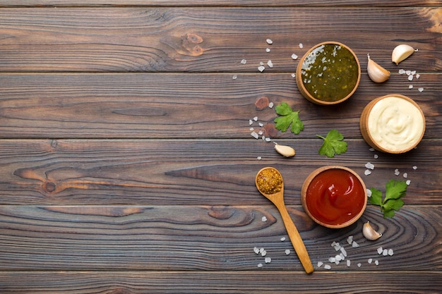 Different sauces in spoons on table background flat lay top view