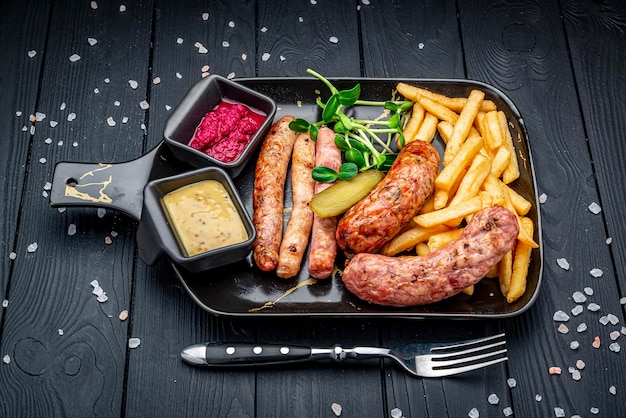 Different sausages in a pan with fried potatoes