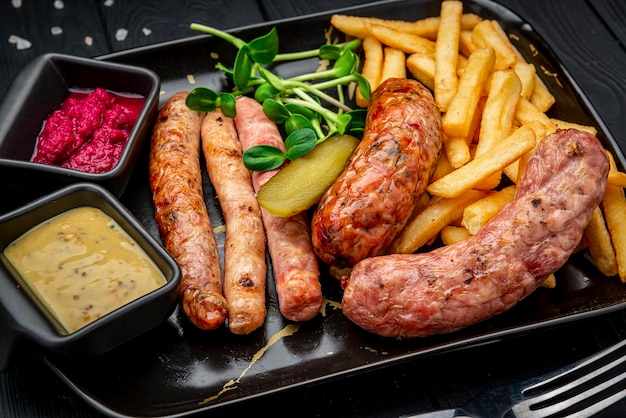 Different sausages in a pan with fried potatoes