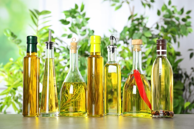 Different sorts of cooking oil in bottles on light grey table