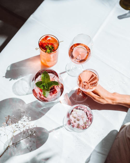 Different sorts of wine and wine cocktails in glasses prepared for tasting on white table indoors so