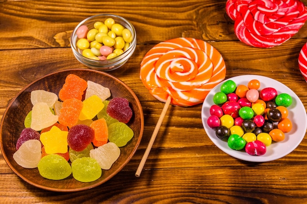 Different sweet candies on rustic wooden table