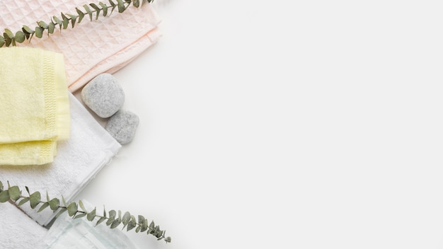 Different type of folded napkins with spa stones and twigs on white background