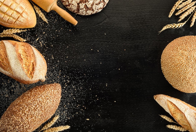 Different types of bread on a black background. Top view.