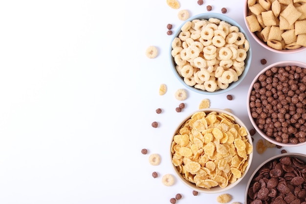 Different types of breakfast cereals on a light background closeup