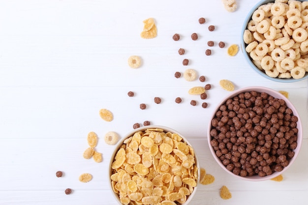 Different types of breakfast cereals on a light background closeup