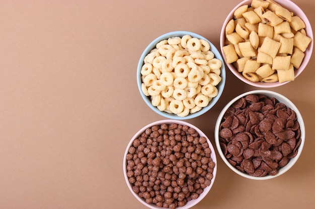 Different types of breakfast cereals on a light background closeup