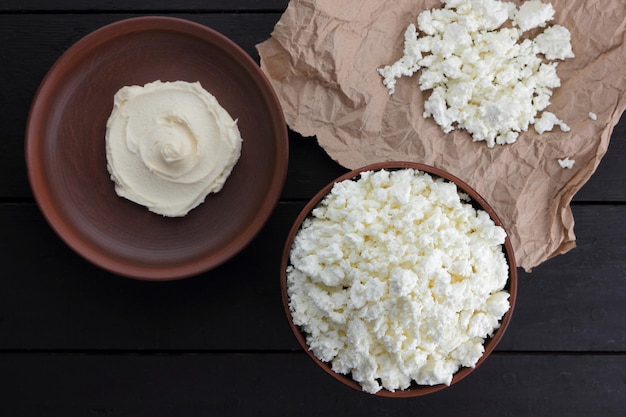 Different types of cheeses on a clay plate on a black wooden background Closeup of healthy breakfast food