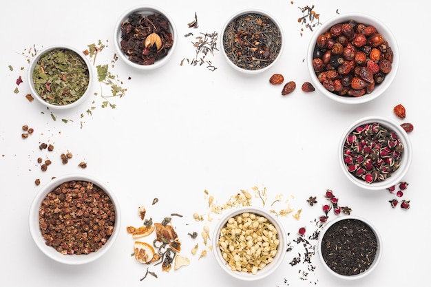 Different types of teas in bowls on white background