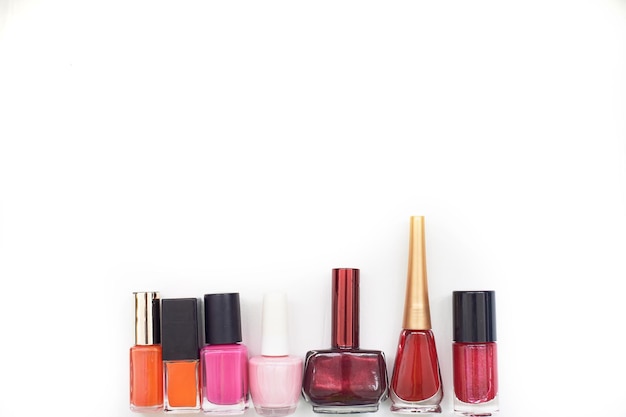 Different varnishes lie in a row on a white backgroundChoice in the beauty salon A variety of colors A place for text