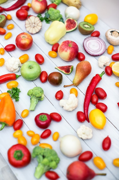 Different vegetables and fruits on a wooden background top view.