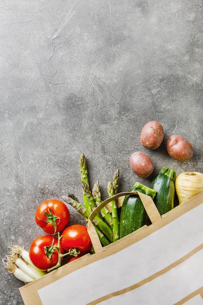 Different vegetables in textile bag on grey