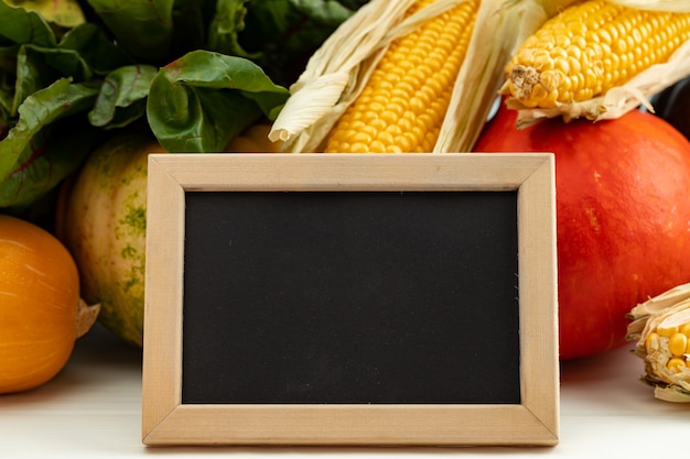 different vegetables with empty chalkboard