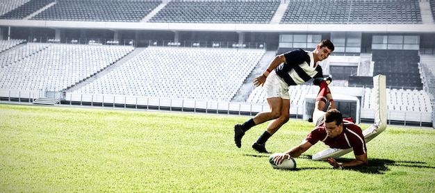 Digital composite image of two rugby players holding ball in sports stadium