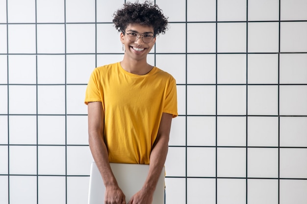 Digital generation. African american young guy in eyeglasses holding a laptop