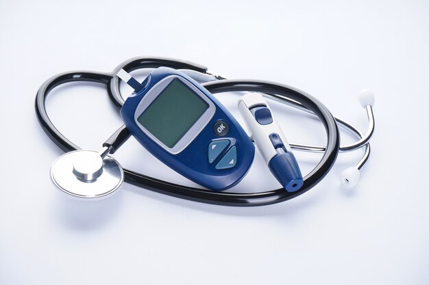 Digital glucometer and lancet pen with stethoscope isolated