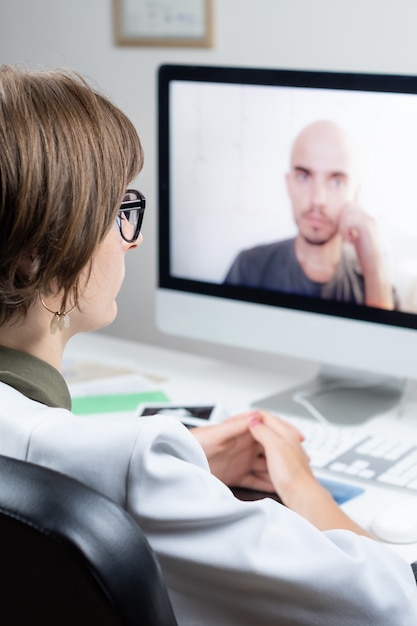 Digital health concept: practicing physician having online appointment with a patient. Medical doctor consulting a person by means of web conference system