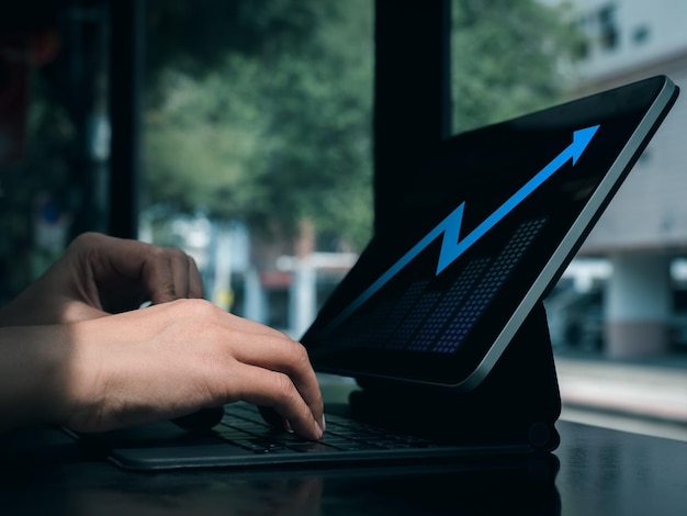 Digital investment analysis trading financial business growth concepts Blue glowing arrow with grow graph on tablet computer screen using by business people trader who invest online stock market