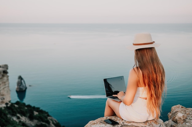 Digital nomad business woman working on laptop by the sea pretty lady typing on computer by the sea