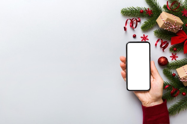 Digital phone mock up with rustic Christmas decorations for app presentation top view with empty space for you design Christmas online shopping concept Tablet with copy space on colored background