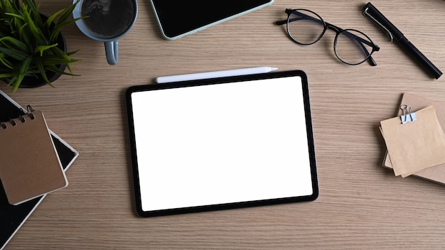 Digital tablet, glasses, notebook and coffee cup on desk