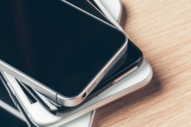 Digital tablet and mobile phone. Electronic devices on wooden table, close up.