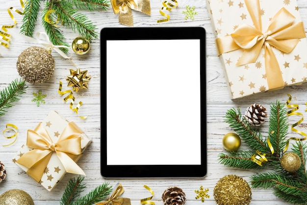 Digital tablet mock up with rustic Christmas decorations for app presentation top view with empty space for you design Christmas online shopping concept Tablet with copy space on colored background