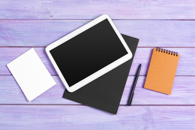 Digital tablet and notepad office on purple