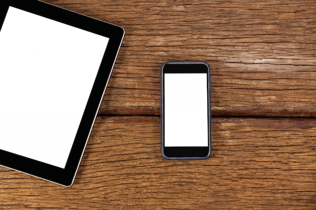 Digital tablet and smartphone on wooden plank