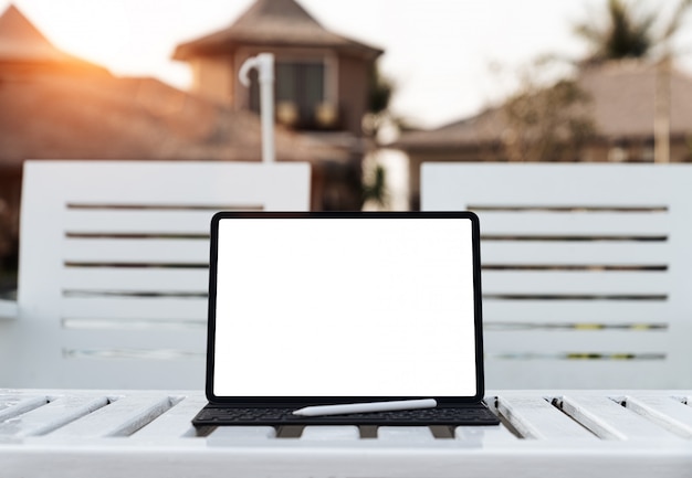 Digital tablet white screen on table at sunset