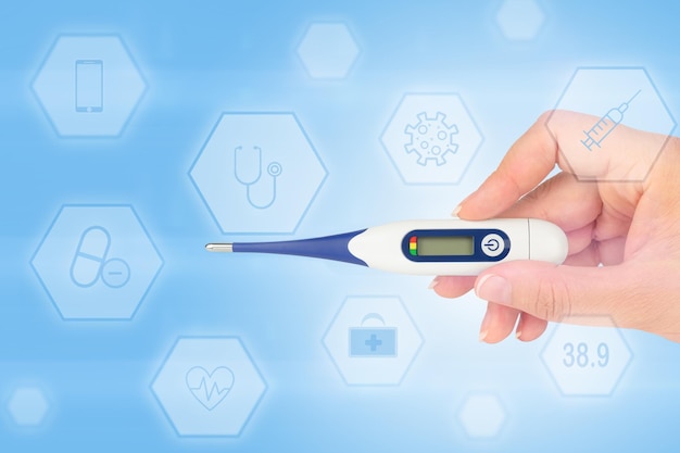 Digital thermometer in hand isolated heavenly background