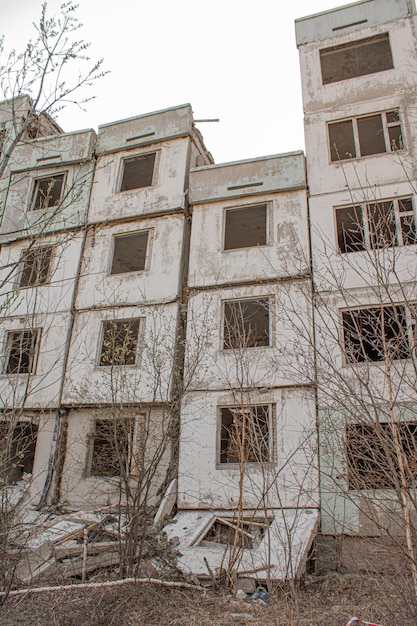 Dilapidated residential building with empty windows collapsed roof collapsed roof