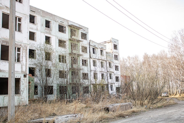 Dilapidated residential building with empty windows collapsed roof collapsed roof