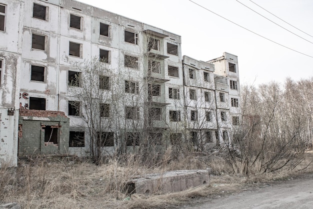 Dilapidated residential building with empty windows collapsed roof