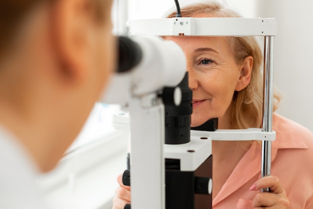 Diligent calm woman accurately putting her face into special frame