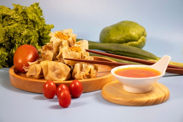 Dimsum Served on wooden utensils with the main sauce