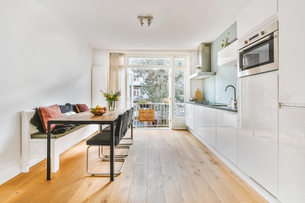 Dining area interior with access to the balcony and corner kitchen in a cozy house